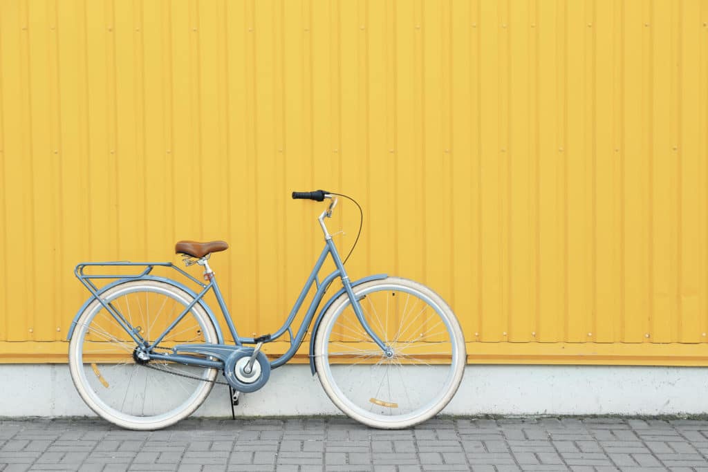 Bicicleta apostada sobre pared de color amarillo